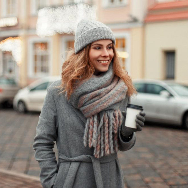 &lt;p&gt;Happy young woman smiling in a trendy coat with a knitted vintage hat and fashionable warm scarf with a coffee walk in the city on a winter day&lt;/p&gt;