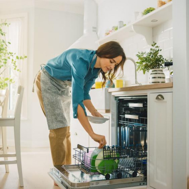 &lt;p&gt;Beautiful Female is Loading Dirty Plates into a Dishwasher Machine in a Bright Sunny Kitchen. Girl in Wearing an Apron. Young Housewife Uses Modern Appliance to Keep the Home Clean.&lt;/p&gt;