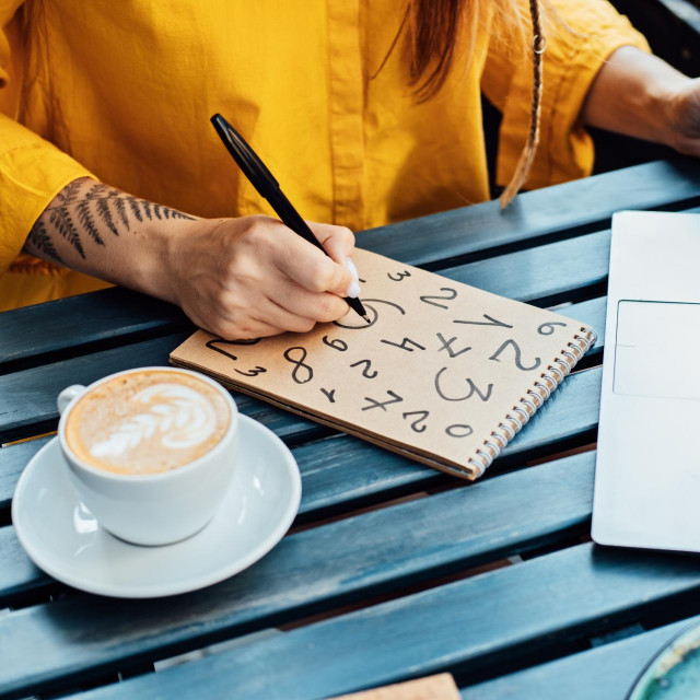 &lt;p&gt;Woman freelancer writing numbers in notepad while working with laptop in street cafe. Time Management&lt;/p&gt;