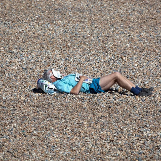 Čovjek spava na plaži (ilustracija)