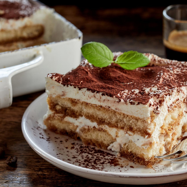 &lt;p&gt;Close up on a portion of gourmet tiramisu Italian dessert topped with a sprig of mint served on a plate at table in a side view&lt;/p&gt;
