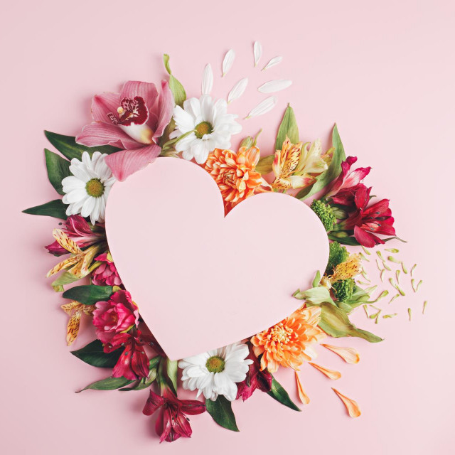 &lt;p&gt;Heart surrounded with fresh colorful flowers on pastel pink background. Creative love layout with copy space. Valentines day, wedding or romantic visual trend. Spring bloom. Flat lay.&lt;/p&gt;