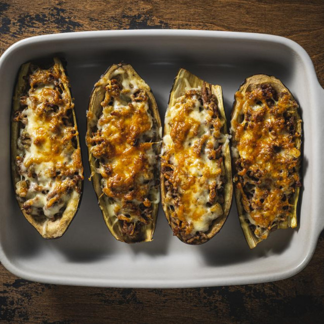&lt;p&gt;Stuffed Eggplants with minced meat recipe italian Aubergine Parmigiana or Eggplant parmesan on rustic wood table in an oven tray&lt;/p&gt;