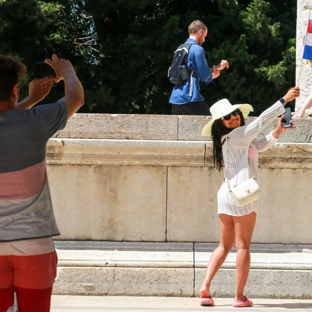 &lt;p&gt;Turistkinja s hrvatskom zastavicom pozira na trgu Forum&lt;/p&gt;