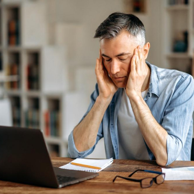 &lt;p&gt;Mature caucasian gray-haired exhausted man, manager or freelancer, sitting at work desk, holding his head with his hands, tired of working in laptop, have a headache, migraine, need rest&lt;/p&gt;