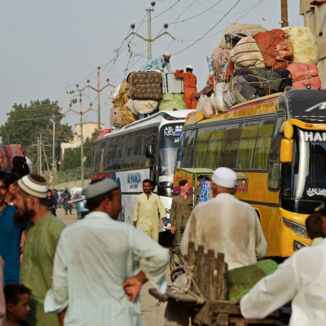 Afganistanske izbjeglice ukrcavaju svoje stvari u autobus na autobusnom kolodvoru u Karachiju