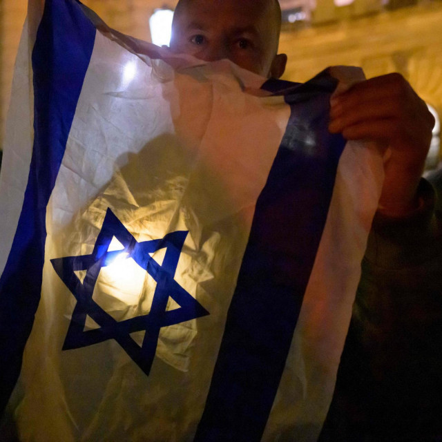 &lt;p&gt;Sudionik pozira sa zastavom Izraela tijekom komemoracije pod motom ‘Svjetlo nade‘ - protiv zaborava, antisemitizma i govora mržnje, ispred palače Hofburg u Beču 9. studenog 2023., na 85. godišnjicu Kristalne noći.&lt;/p&gt;