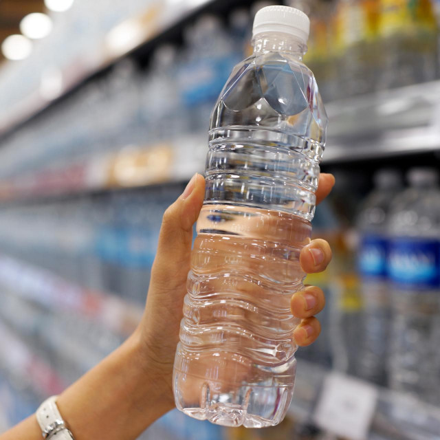 &lt;p&gt;Close up female hand holding a bottle of water or mineral water in grocery store.&lt;/p&gt;