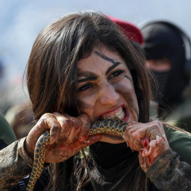 Časnica kurdskih pešmergi grize zmiju u jednom od izazova u obuci