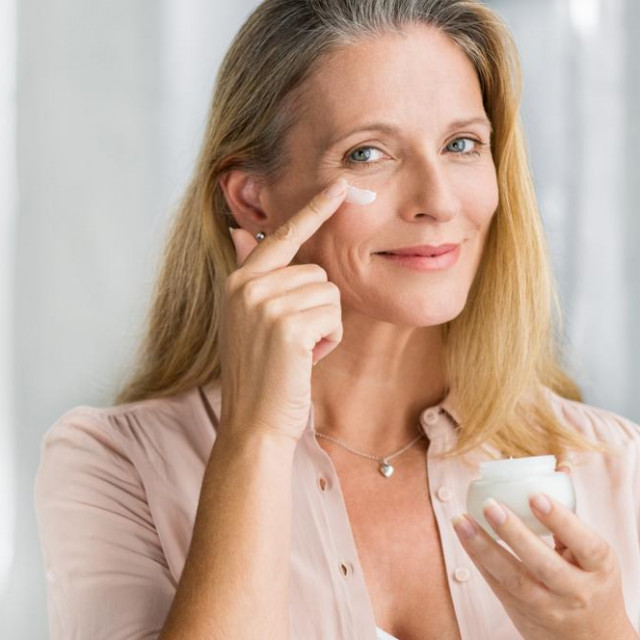 &lt;p&gt;Smiling senior woman applying anti-aging lotion to remove dark circles under eyes. Happy mature woman using cosmetic cream to hide wrinkles below eyes. Lady using day moisturizer.&lt;/p&gt;