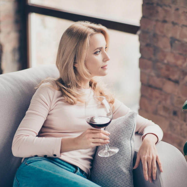 &lt;p&gt;Charming, attractive, pretty, stylish woman, having glass with wine in hand sitting on couch with serious expression looking at window, thinking about something&lt;/p&gt;