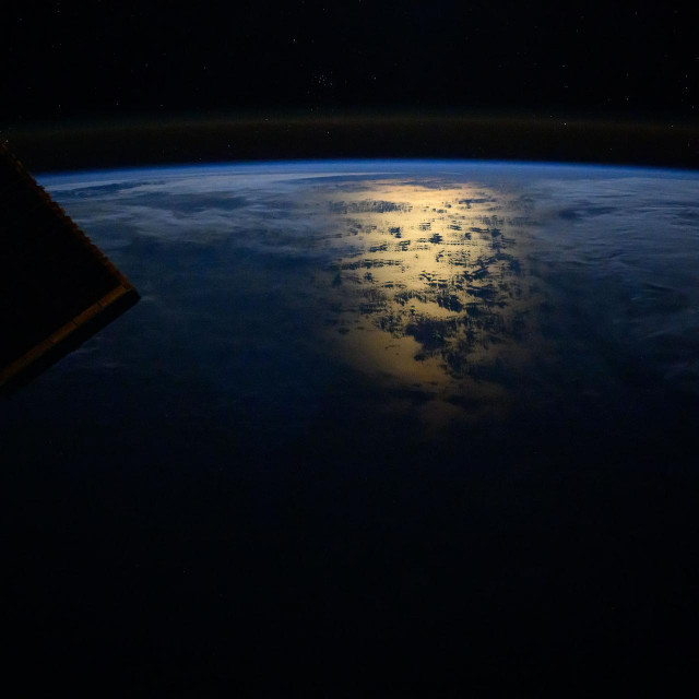 Sunčev odsjaj koji zrači s južnog Tihog oceana u blizini obale Čilea odmah nakon orbitalnog izlaska sunca i blagi sjaj zraka koji kruni Zemljin horizont fotografirani su s Međunarodne svemirske postaje