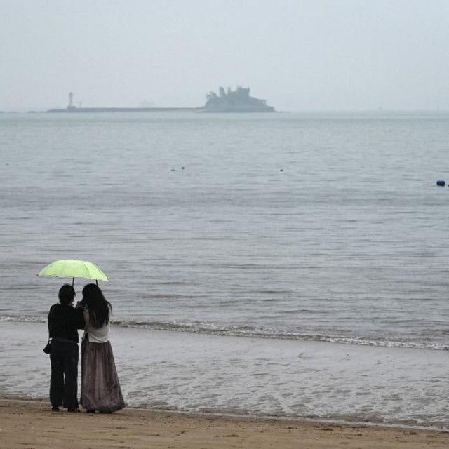 Ljudi s plaže u Xiamenu u jugoistočnoj kineskoj provinciji Fujian gledaju prema tajvanskom otoku Kinmen
