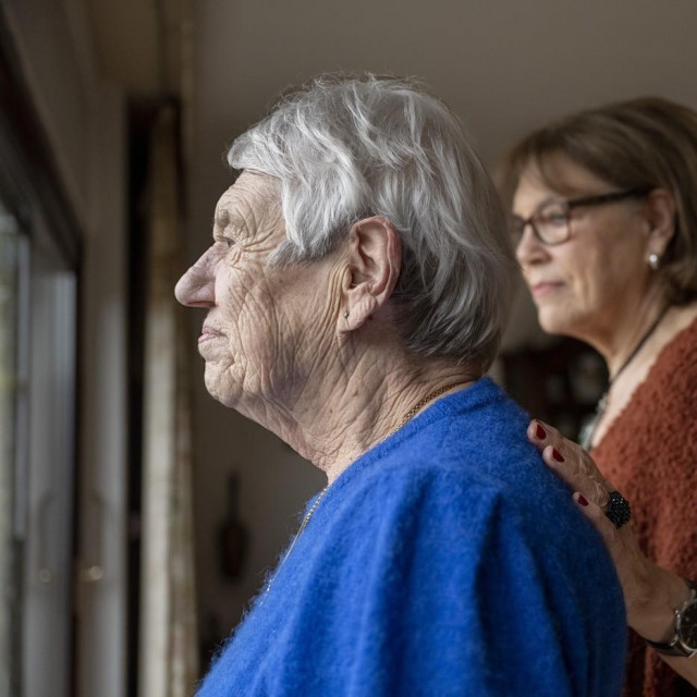 Starija osoba gleda kroz prozor, ilustrativna fotografija