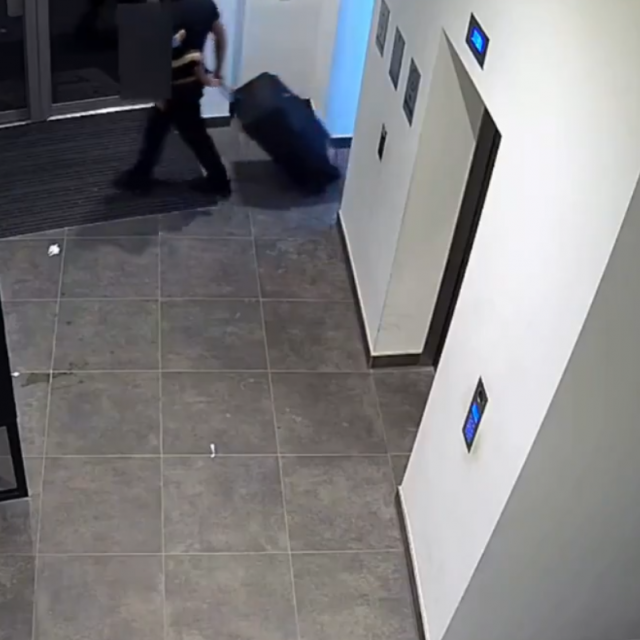 Ubojica s koferom izlazi iz zgrade