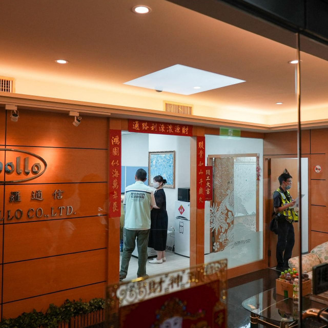 Employees of Taiwanese company Gold Apollo are seen behind the glass doors of their office ahead of a press briefing by company head Hsu Ching-kuang in New Taipei City on September 18, 2024. Taiwanese company Gold Apollo on September 18 denied a report that it had produced hundreds of explosive-packed pagers used by Hezbollah members which simultaneously exploded, killing at least nine people. (Photo by Yan ZHAO/AFP)