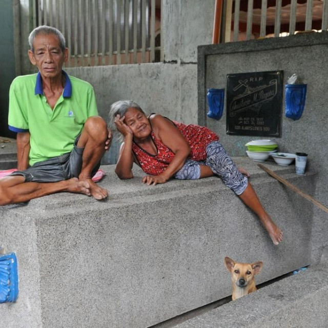 Dvoje Filipinaca i pas na groblju u Manili