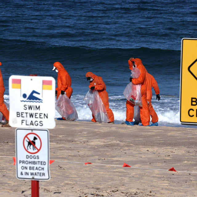 Radnici u zaštitnim odijelima čiste plažu u Sydneyu od crnih smrdljivih loptica