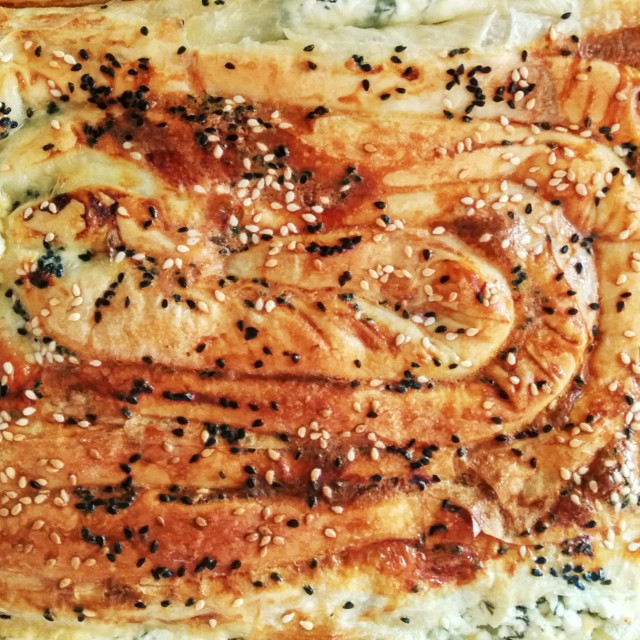 Close-up pattern of traditional Bulgarian home-baked Banitsa (Pie with cheese and eggs). Food background