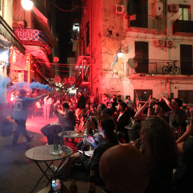 Supporters of Napoli cheer their team as they watch the Italian Serie A football match between Parma and Napoli on TV, in a street of the ”Spagnoli‘ neighborhood in Naples on May 18, 2025. (Photo by Carlo Hermann/AFP)